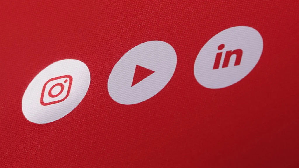Drei weiße Social-Media-Symbole Instagram, YouTube und LinkedIn auf rotem Hintergrund