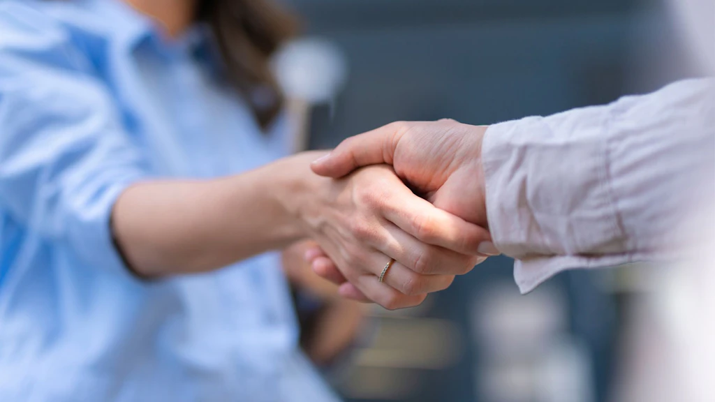 Nahaufnahme von zwei Personen, die sich die Hand geben