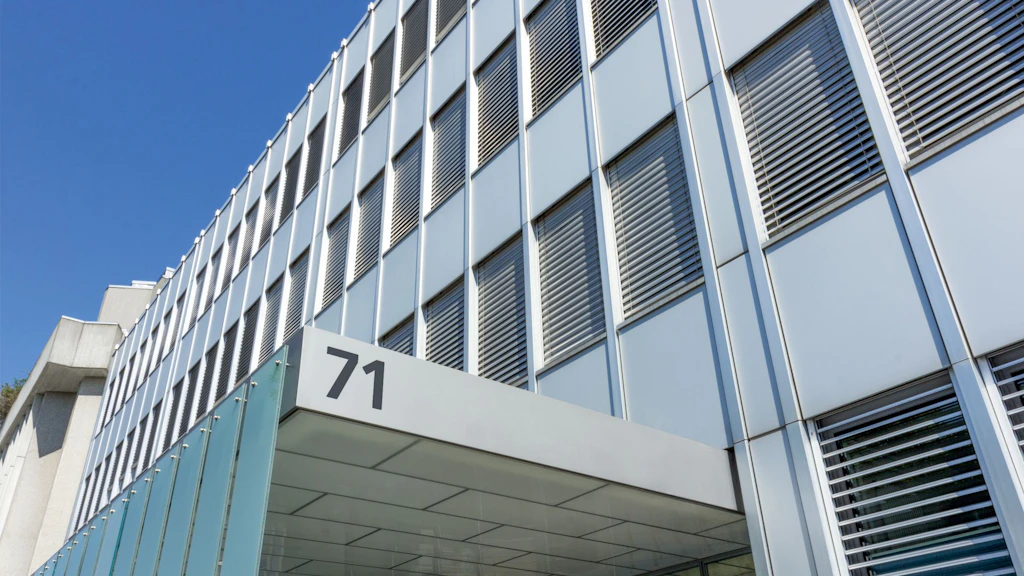 Façade moderne d'un immeuble de bureaux avec le numéro 71 à l'entrée