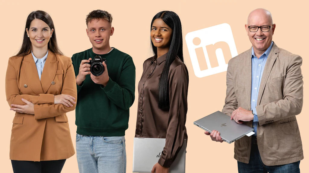 Quatre personnes debout côte à côte devant un fond beige avec logo LinkedIn deux tiennent des ordinateurs portables une tient un appareil photo