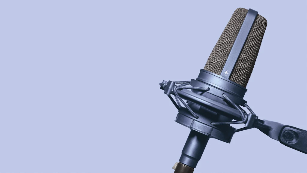 Primo piano di microfono da studio professionale con supporto antivibrazione su sfondo uniforme