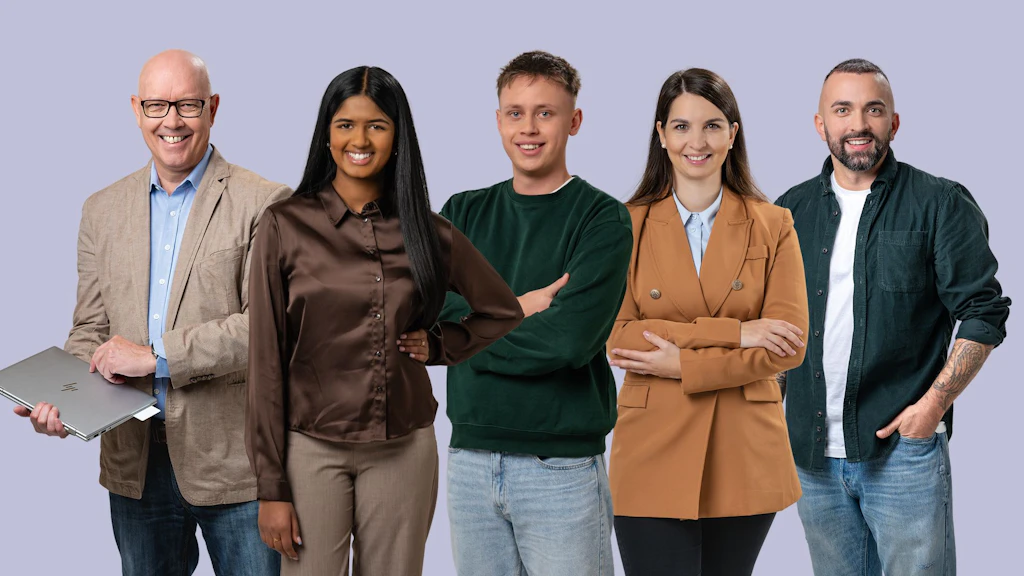 Cinque persone in piedi davanti a uno sfondo uniforme due con le braccia incrociate una che tiene un portatile